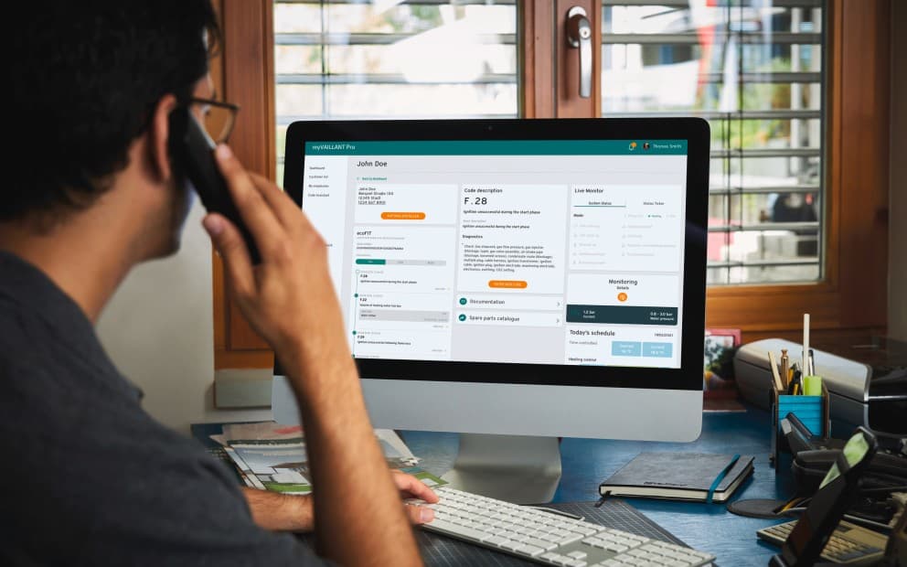 Een man aan de telefoon die naar het scherm kijkt.