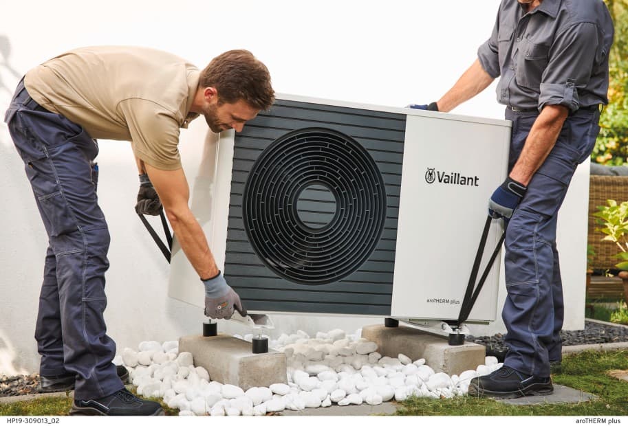 Twee installateurs dragen een warmtepomp