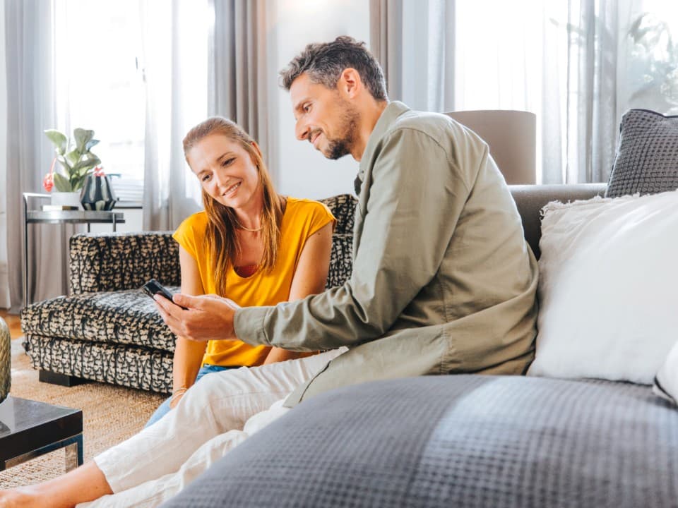 Man en vrouw kijken op mobiel naar myVAILLANT app