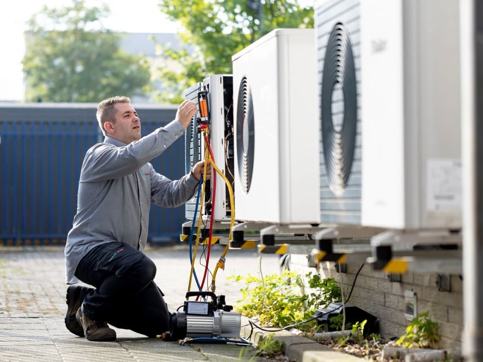 Medewerker Vaillant sleutelt aan warmtepomp buitenunit